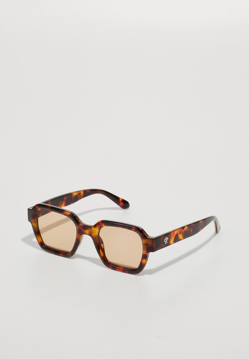 Tortoiseshell sunglasses with square frames, brown tinted lenses, and a glossy finish. Subtle logo accents on the temples.