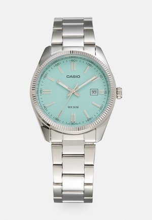 Silver metal Casio wristwatch with light blue face, date display, and water resistance up to 50 meters shown from front.