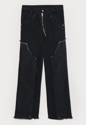 Schwarze Jeanshose mit weitem Bein, fransigen Säumen, auffälligen Ausschnitten und einem Reißverschluss. Hardware-Akzente an den Taschen.