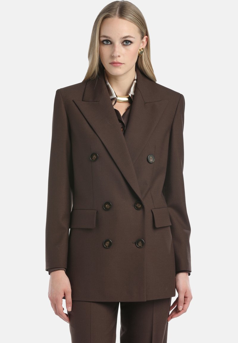 Bruine dubbelgeknoopte blazer met brede revers, twee voorkeurszakken en grote zwarte knopen. Gemaakt van een gestructureerde stof.
