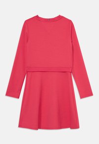 Ilgām piedurknēm rozā kleita ar noapaļotu kakla izgriezumu, izcelta jostas daļa un izsistā svārku daļa. Mīksta auduma ar maigu tekstūru un detalizētu šuvju apdari.