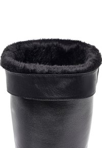 Zwarte leren laars met een zachte, fuzzy zwarte voering aan de bovenkant, met een gladde buitenkant en een omgeslagen rand.