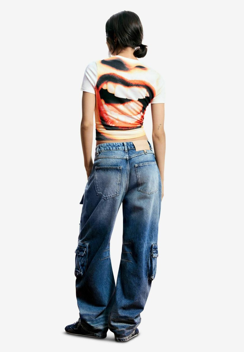 Grafické tričko s veľkým potlačeným motívom úst, krátke rukávy. Kombinované s voľnejšími svetlomodrými denimovými cargo nohavicami s vreckami a vyblednutým efektom.