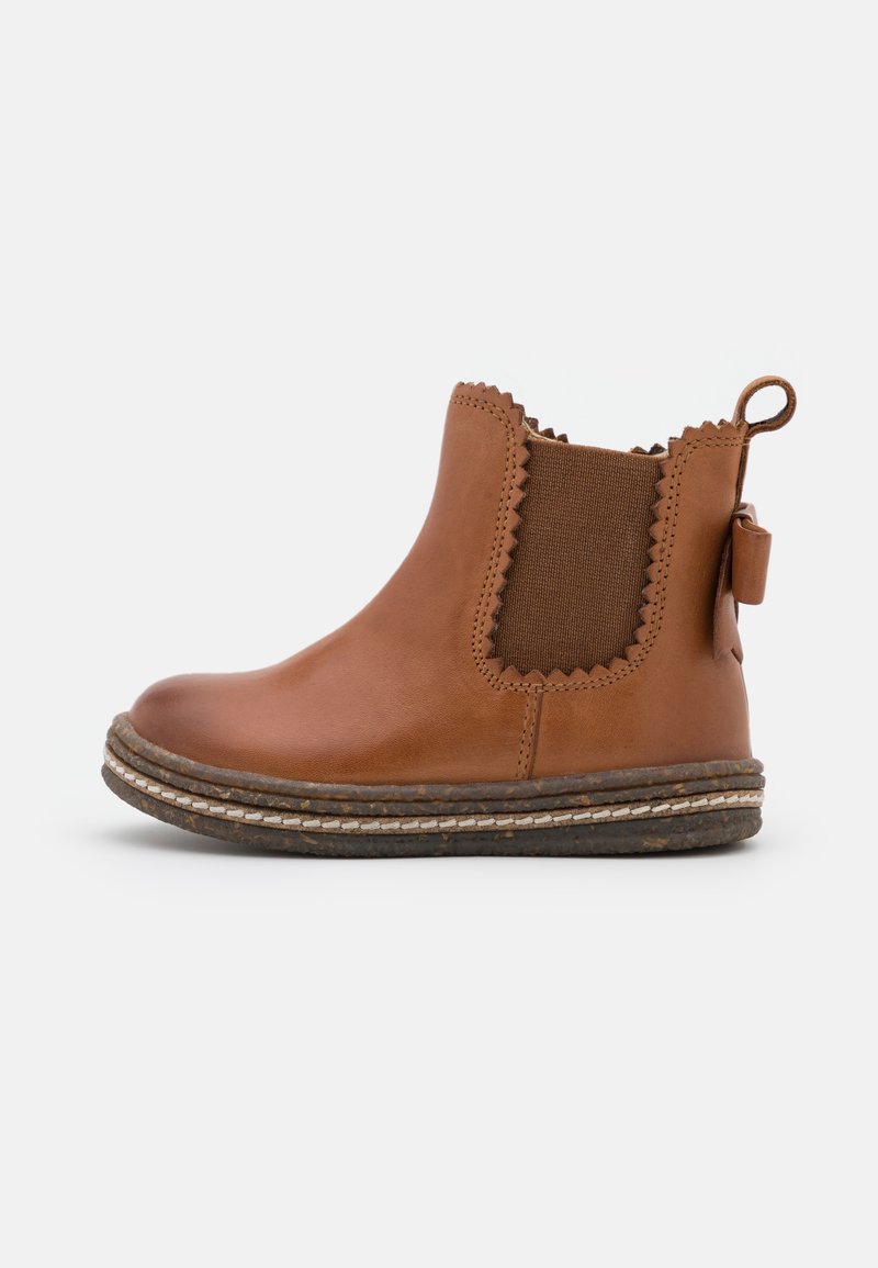 Botte chelsea en cuir marron avec des panneaux élastiques latéraux, des bords festonnés et une boucle décorative au talon ; dotée d'une semelle en caoutchouc texturée.