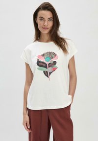 Weißes T-Shirt mit kurzen Ärmeln, das ein farbenfrohes Blumendesign in Pink, Türkis und Braun zeigt. Weicher Stoff und lockere Passform.
