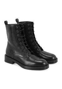 Bottines noires en cuir avec une texture lisse, dotées d'un laçage, d'une languette au talon et d'une semelle en caoutchouc robuste.