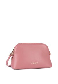Borsa a tracolla in pelle rosa con una superficie liscia, forma arrotondata e hardware dorato. Presenta una chiusura a cerniera e una tracolla corta.