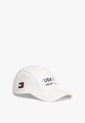 Biała czapka z daszkiem z napisem „USA SAIL GP TEAM” i flagą USA z przodu oraz naszywką z logo Tommy Hilfiger z boku.