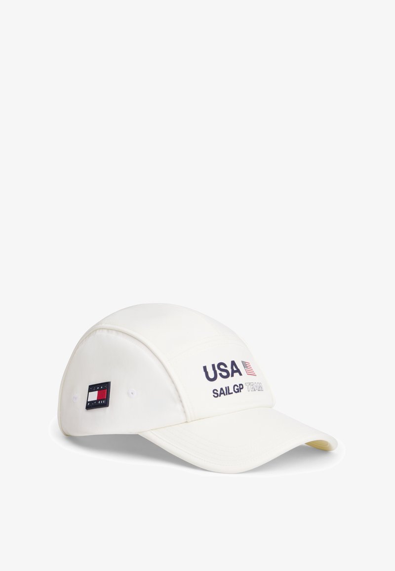 Άσπρο καπέλο μπέιζμπολ με το κείμενο «USA SAIL GP TEAM» και τη σημαία των ΗΠΑ μπροστά, και ένα λογότυπο της Tommy Hilfiger στο πλάι.
