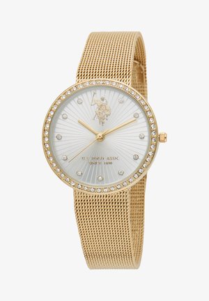 Montre-bracelet en maille dorée avec un cadran ovale, des accents en cristal et un cadran blanc texturé présentant un motif en éventail et un logo.