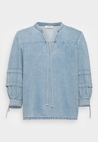 Ljusblå denimblus med rund hals, elastiska puffärmar och dragsko stängning. Har samlade detaljer och en avslappnad passform.