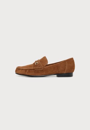Brauner Wildleder-Flats mit einer kleinen goldenen Schnalle am Obermaterial und einer schwarzen Sohle vor weißem Hintergrund.