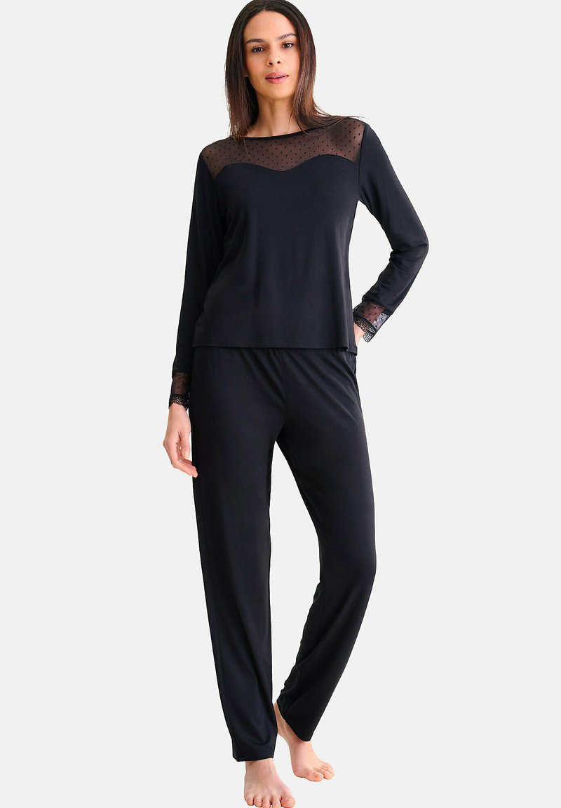 Ensemble de vêtements d'intérieur noir comprenant un haut à manches longues avec superposition en tulle à pois et un pantalon élastique assorti, fabriqué à partir d'un tissu doux.