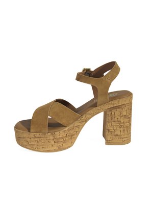 Brown suede platform sandals with an ankle strap. Cork-textured block heel, cross-strap design, and a smooth interior sole.