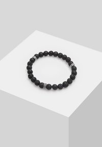 Bracciale in pietra lavica nera con bead decorativi in argento. Forma rotonda, superficie texture, e design elastico per un facile indosso.