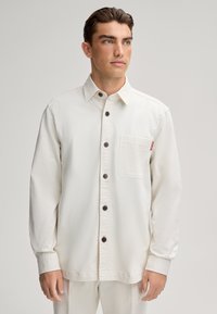 Witte overhemd met knopen, gemaakt van gestructureerde stof, voorzien van een borstzak, donkere knopen en een casual pasvorm.