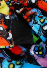 Materiał polarowy w żywych kolorach zawiera mieszankę wzorów z kreskówek. Widać czarny, prążkowany mankiet, który podkreśla teksturę tkaniny.