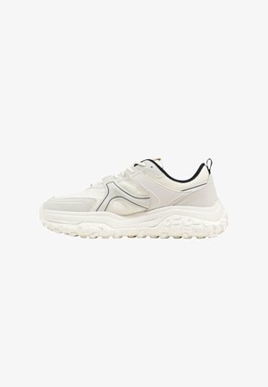 Baskets blanches épaisses avec semelle texturée, panneaux en mesh et cuir, doublure intérieure noire et languette de tirage au talon, vues de profil.