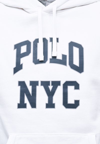 Λευκό φούτερ με κουκούλα, με κείμενο "POLO NYC" σε σκούρο γκρι χρώμα και λευκά κορδόνια που κρέμονται πάνω από το κείμενο κοντά στον λαιμό.