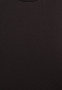 Texture de tissu en noir uni avec un léger motif de tissage fin et des reflets subtils de lumière naturelle.