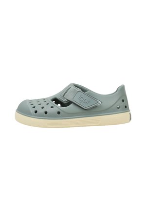 Sandalia de goma para niños de color azul claro con perforaciones, cinta ajustable de velcro con la etiqueta "igor" y suela beige.