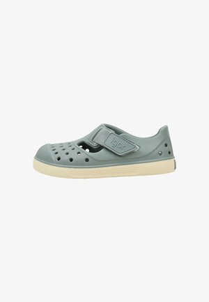 Sandale en caoutchouc bleu clair pour enfant avec perforations, bride Velcro réglable étiquetée « igor » et semelle beige.