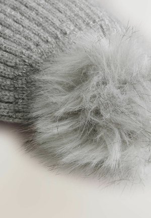 Kootud hall beanie metallniitidega ja koheva, hõbedase pom-pomiga. Tekstuur on pehme ja visuaalselt läikiv.