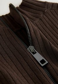 Material tricotat maro cu dungi, cu un guler înalt și un detaliu de fermoar negru, prezentând o textură netedă și nuanțe contrastante.