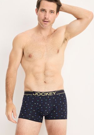 Boxer briefs para hombres Jockey en color navy con un patrón geométrico de triángulos en verde y azul, con una cintura elástica dorada.