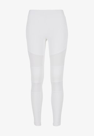 White leggings featuring a mix of solid and mesh panels, a high waistband, and a sleek, fitted silhouette. Smooth texture throughout.