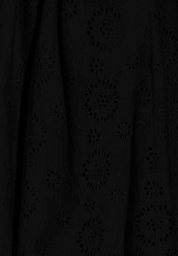 Schwarzer Stoff mit floralem Stickmuster und Ausschnittdetails. Die Textur wirkt glatt, mit einem subtilen Glanz, der das komplizierte Design betont.