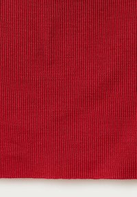 Gros plan d’un tissu rouge tricoté serré montrant une texture côtelée verticale et un motif de couture uniforme.