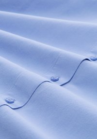 Material de culoare albastră deschisă cu textură netedă, având două butoane albastre deschise de-a lungul unei cusături.