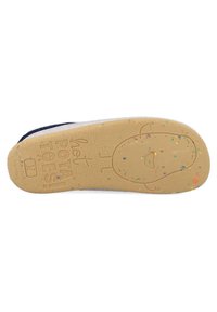 Suela de una zapatilla de goma beige con manchas multicolores, que presenta un diseño en relieve de un personaje de dibujos animados y texto de la marca en la superficie.