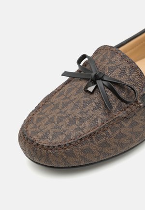 Brązowe loafersy w wzory z teksturowanym wykończeniem, z czarną kokardą i kontrastowym przeszyciem wzdłuż krawędzi.
