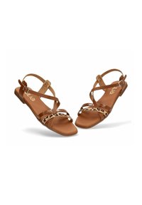 Sandalias planas marrones con diseño de tiras cruzadas, un acento de estampado de leopardo y una textura suave en la plantilla. Cierre con hebilla en el tobillo.