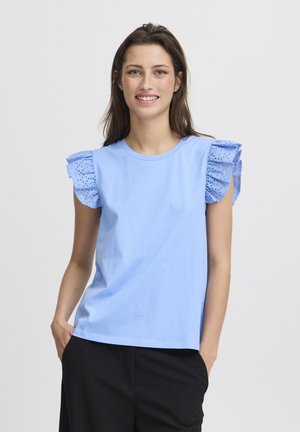 T-shirt en coton bleu clair avec des manches courtes volantées et des détails en œillets. Encolure ronde et coupe décontractée, associé à un bas noir.