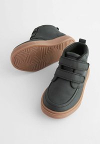 Scarpe nere in velcro con una finitura liscia e punta arrotondata. Suola in gomma con un motivo geometrico. Fodera interna morbida per maggior comfort.