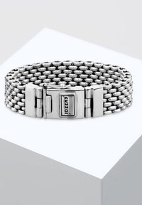 Silverfärgad metallarmband med sammanlänkade länkar, har en lås med vakuumklausul och en logotyp. Slät yta och rund form, lämplig för avslappnad användning.