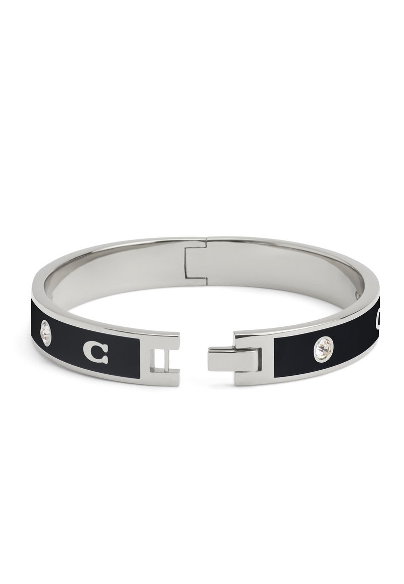 Bangle armband met een slanke zilverkleurige metalen band met een zwarte inleg, verfraaid met een kristal en een ontwerp van de letter "C".