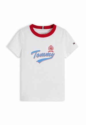 T-shirt blanc à manches courtes avec col rouge, inscription "Tommy" en bleu et rouge, logo écusson sur la poitrine, et petit logo drapeau sur la manche gauche.