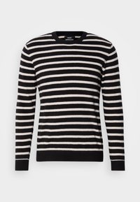 Suéter a rayas blanco y negro hecho de suave tejido de punto. Presenta un cuello redondo y puños y dobladillo acanalados. Diseño simple y clásico.