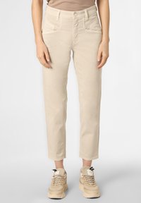 Beige bavlněné kalhoty s rovnou siluetou, vysokým pasem, šikmými předními kapsami a manžetami, spárované s béžovými sneakers.
