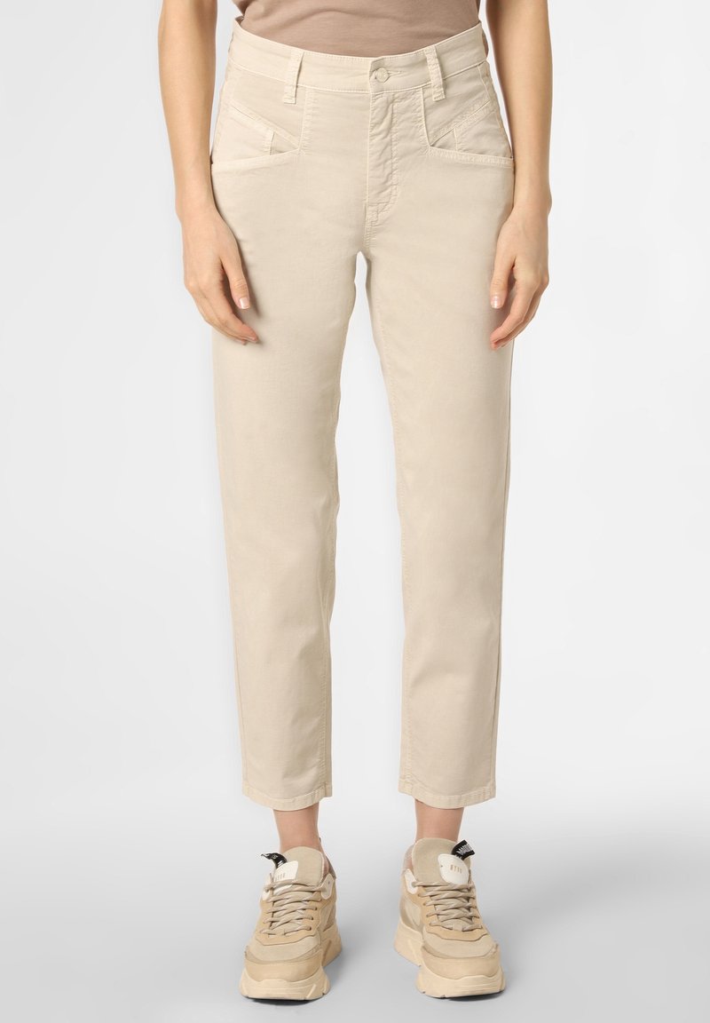 Beige bavlněné kalhoty s rovnou siluetou, vysokým pasem, šikmými předními kapsami a manžetami, spárované s béžovými sneakers.