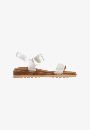 Flat sandal with light brown sole and two shiny silver straps, one over toes and one around ankle, on white background.