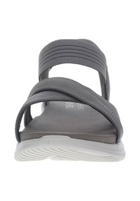 Sandalia gris con un diseño de tira texturizada y una suela acolchada. Las tiras son planas y ligeramente elásticas, lo que proporciona un ajuste seguro.