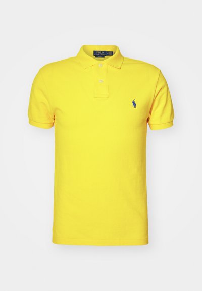 Geltonas polo marškinėliai, pagaminti iš medvilnės, su klasikinio stiliaus apykakle, trimis mygtukais, trumpomis rankovėmis ir mėlynai siuvinėtu logotipu kairėje krūtinės pusėje.