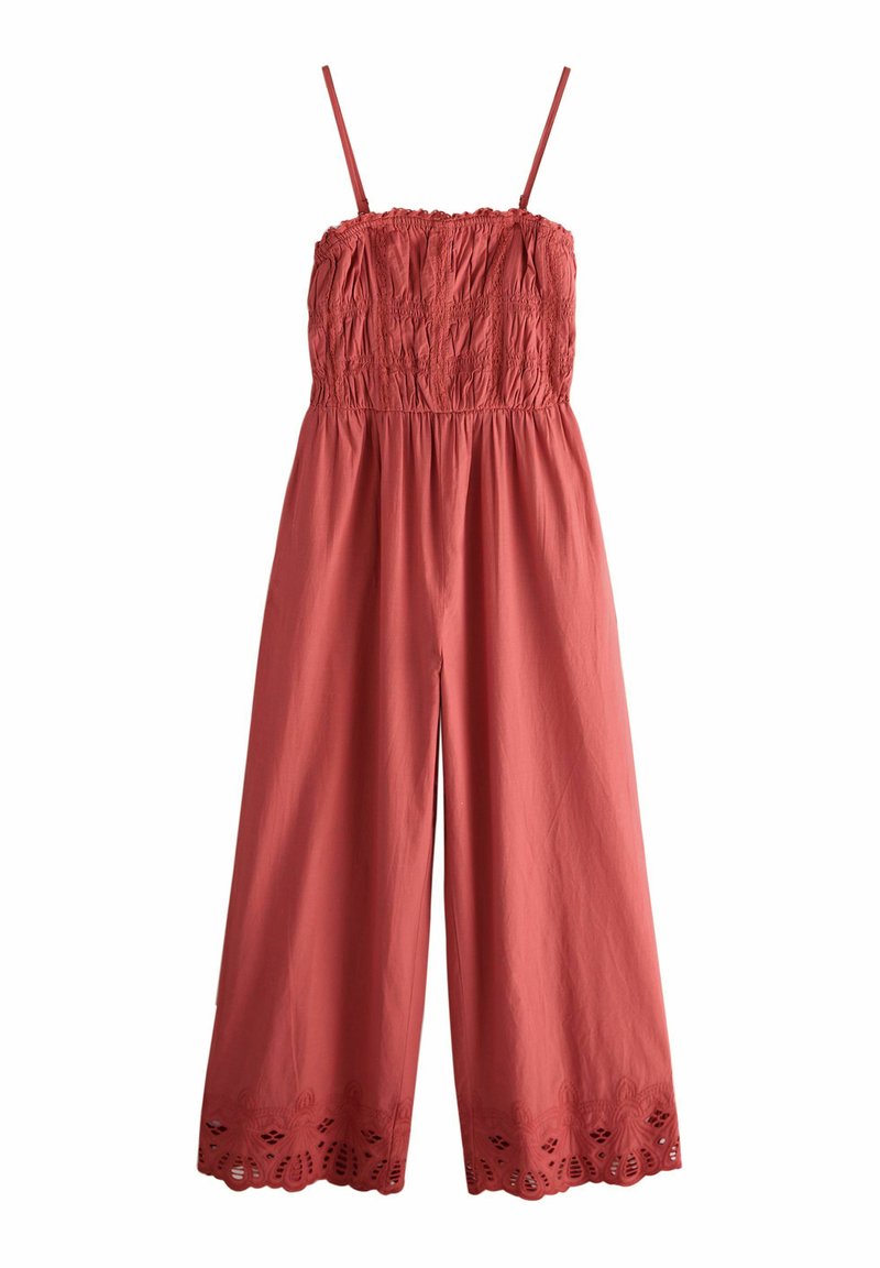 Combinaison rouge avec corsage smocké, fines bretelles, jambes larges et détails brodés au bas. Fabriqué en tissu léger.