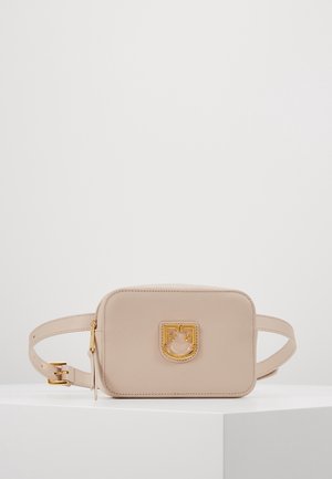 Sac ceinture rectangulaire en cuir beige avec logo et boucle dorés, présenté sur une surface blanche sur fond gris uni.