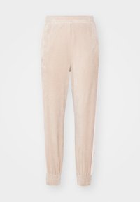 Světle béžové sametové tepláky s elastickým pasem a manžetami, zdobené jemnými vertikálními pruhy po stranách.